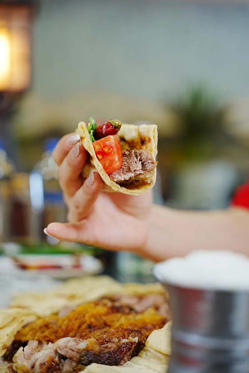 Pideye sarılmış Denizli kebabı lokması, domates, kuru biber ve maydanozla